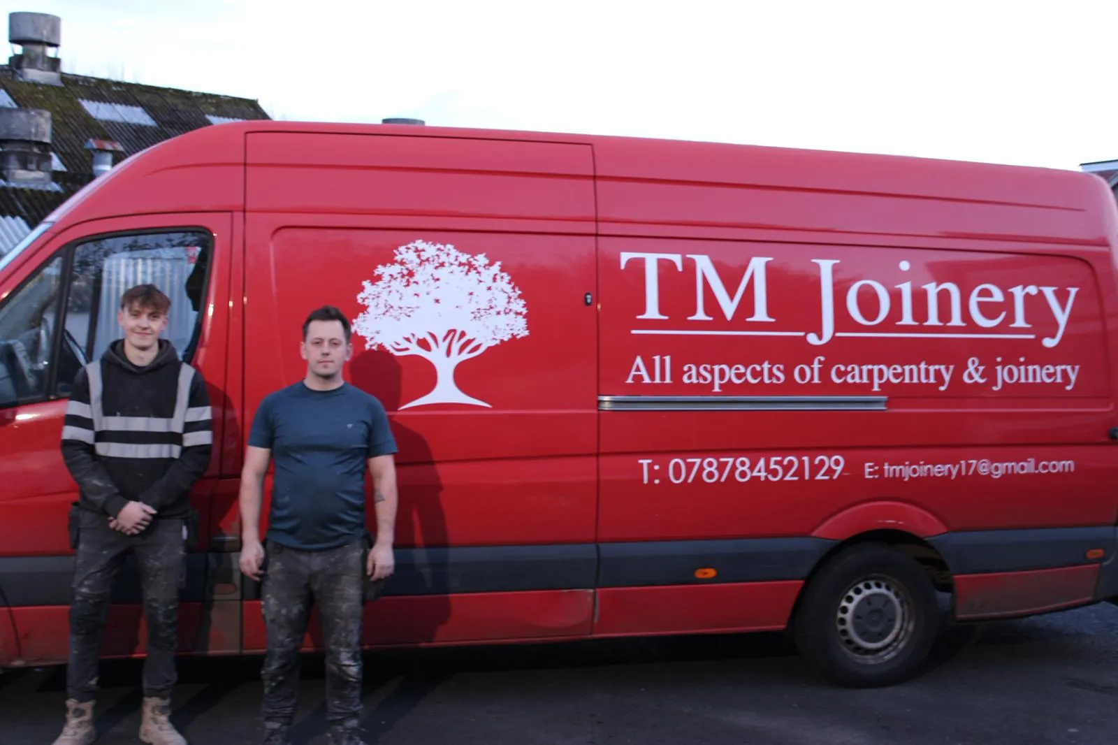 Todd and Elliott from T M Joinery standing in front of the branded red van
